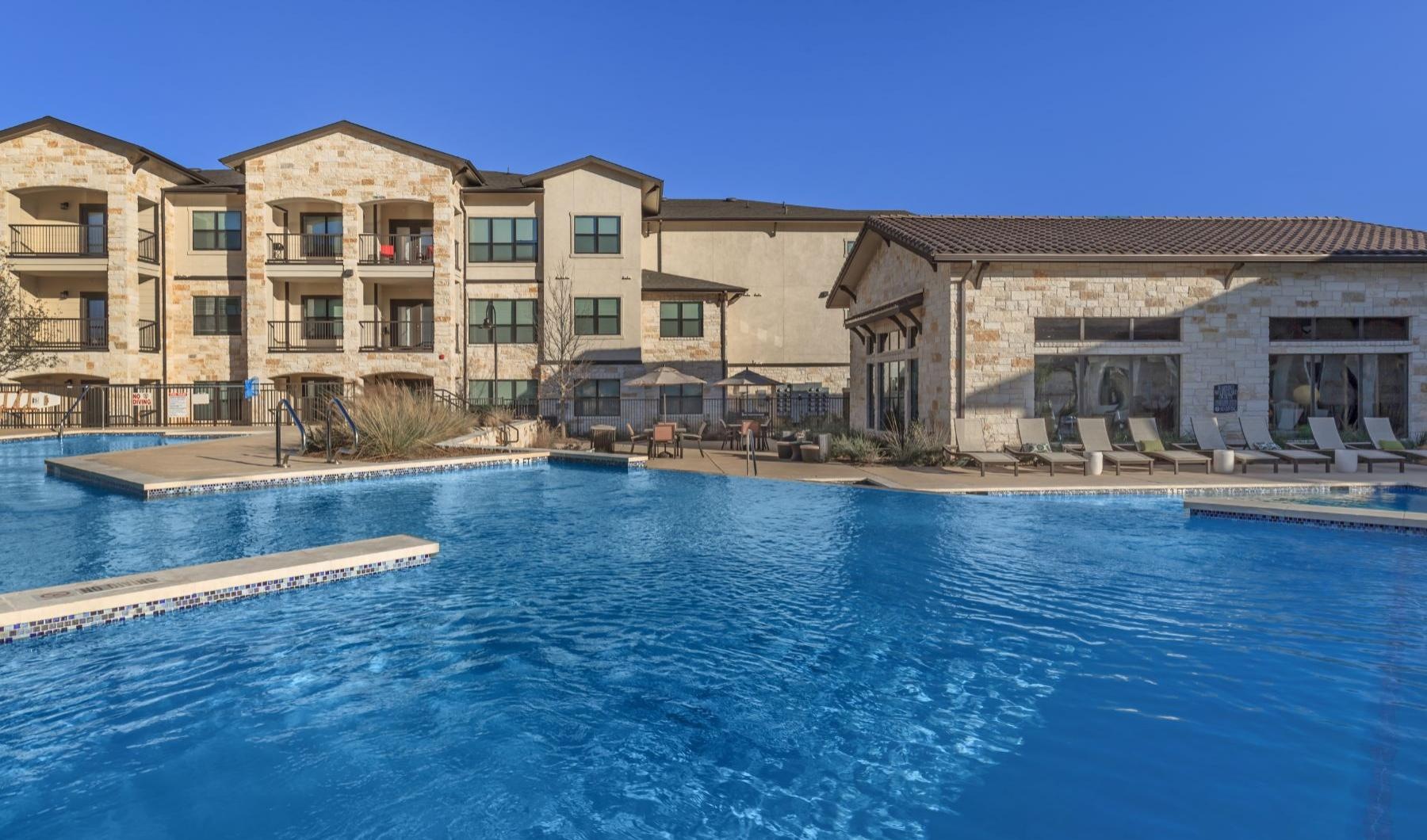 a swimming pool in front of a large building